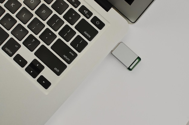 Primer plano de una memoria USB conectada a una computadora portátil que ilustra la importancia de la memoria digital en la era digital