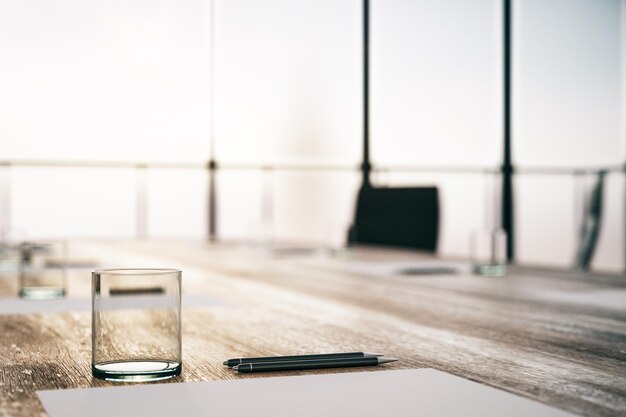 Foto primer plano de una mesa de conferencias de madera con bolígrafos de vidrio y una hoja en blanco en un fondo borroso de la ventana renderización 3d