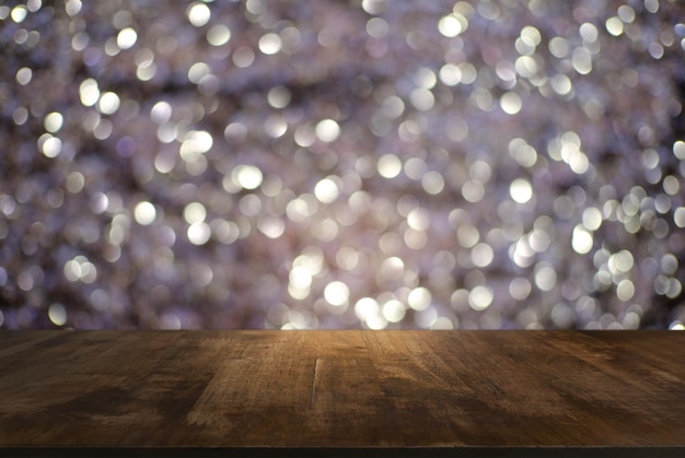Foto primer plano de una mesa de madera contra luces iluminadas
