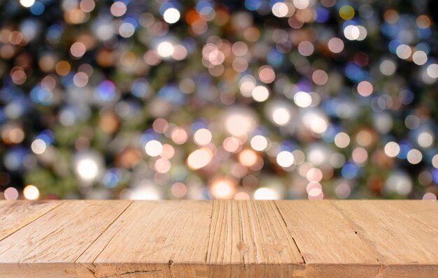 Primer plano de una mesa de madera contra luces iluminadas