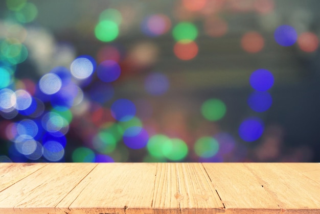 Primer plano de una mesa de madera contra luces iluminadas