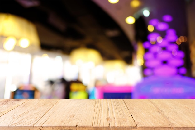 Primer plano de una mesa de madera vacía contra luces iluminadas por la noche