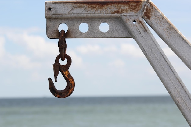 Foto primer plano de metal oxidado por el mar contra el cielo