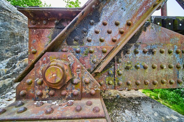 Primer plano de metal texturado oxidado con efecto de derrame de aceite arco iris en el metal de los remaches y la viga del puente