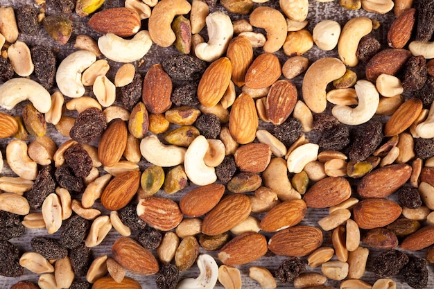 Foto primer plano de la mezcla de nueces crudas saludables sobre fondo de madera en la foto de estudio. merienda orgánica saludable