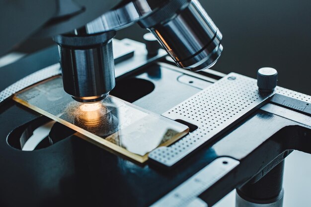 Primer plano de microscopio con lente metálica en laboratorio