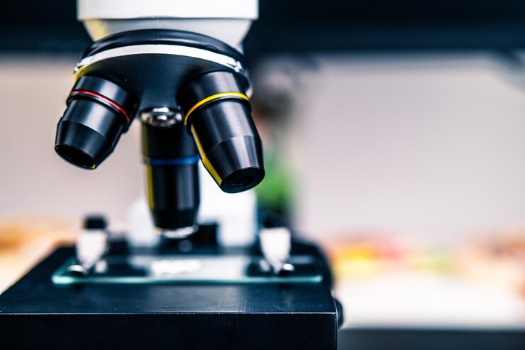 Primer plano de un microscopio moderno con objetivos coloridos en un laboratorio para investigación científica