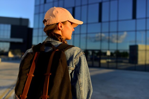 Primer plano de la mochila de las mujeres turísticas Vista trasera de la mujer joven en mezclilla y con mochila negra