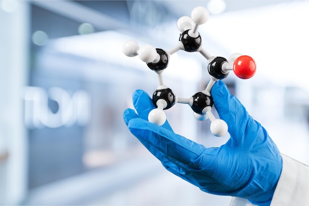 Primer plano del modelo de estructura molecular en la mano sobre el fondo