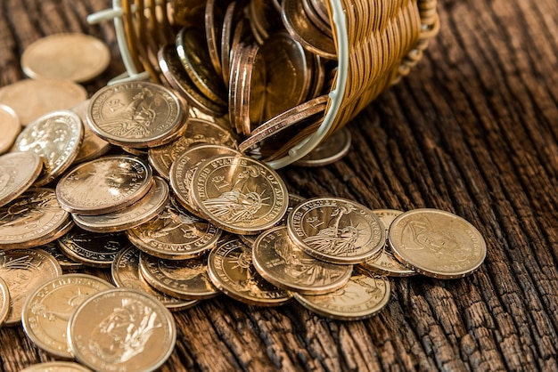 Primer plano de monedas en una canasta sobre una mesa de madera