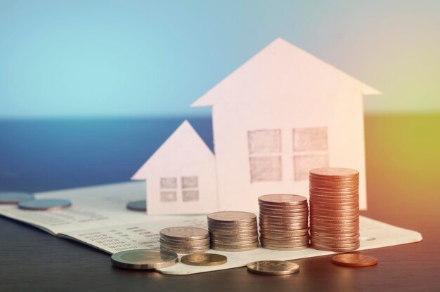 Primer plano de las monedas y la casa modelo sobre la mesa