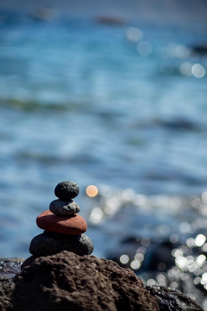 Foto primer plano de monedas en una roca junto al mar