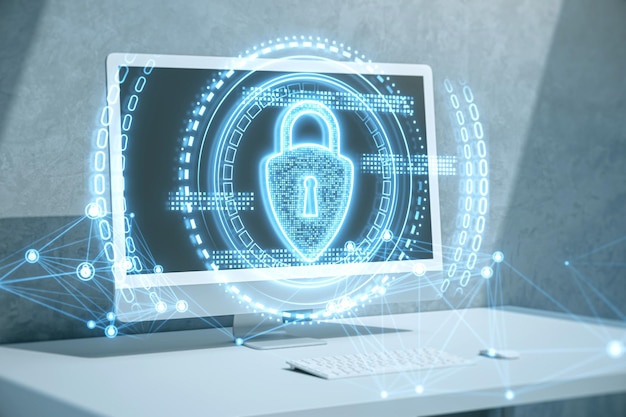 Primer plano del monitor de la computadora en el escritorio con un brillante holograma de candado poligonal sobre fondo borroso Concepto seguro de seguridad y tecnología Doble exposición