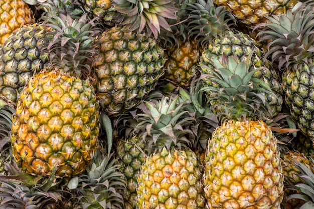 Primer plano de un montón de piña fresca orgánica en un mercado de frutas