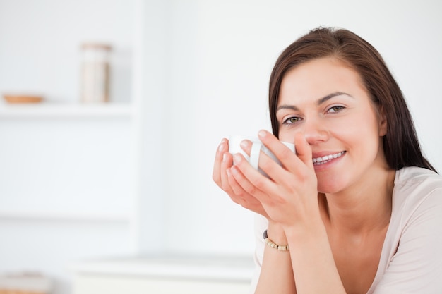 Foto primer plano de una morena disfrutando de un café