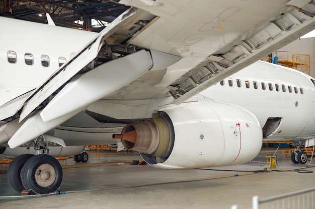 Primer plano de un motor de avión jet en mantenimiento en el hangar en el interior. Avión, envío, concepto de transporte