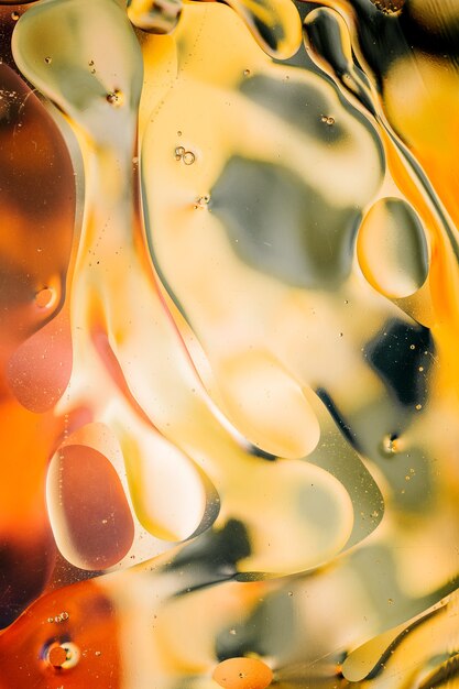 Primer plano del movimiento de las gotas de aceite en la superficie del agua. Fondo macro abstracto colorido de gotas de aceite sobre la superficie del agua.