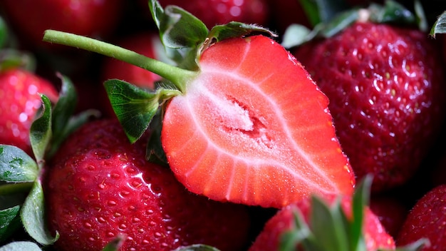 Primer plano de muchas fresas frescas en rodajas fresas jugosas maduras y bayas de vitamina en