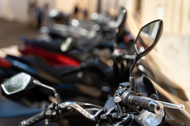 Primer plano de muchas motocicletas en la calle Estacionamiento de bicicletas al aire libre