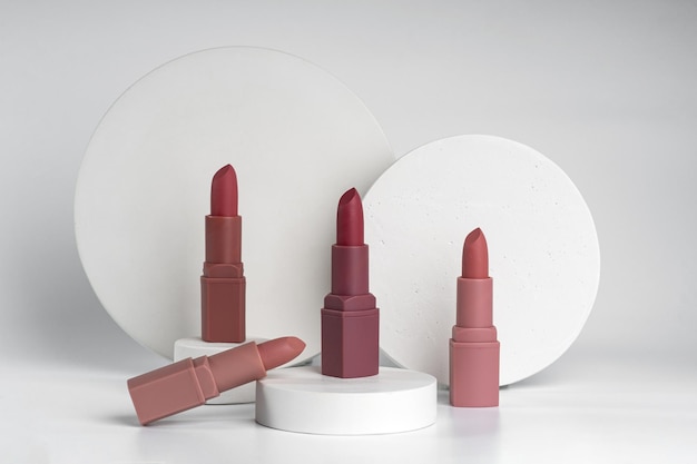 Un primer plano de muestras de lápices de labios con diferentes tonos de colores que se muestran en podios de hormigón blanco