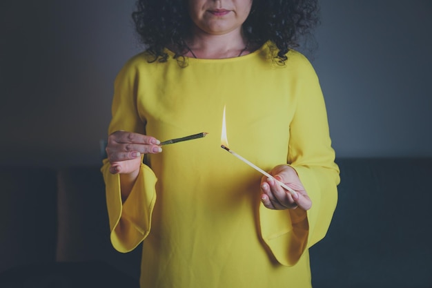 Foto el primer plano de una mujer adulta se ilumina con fósforos y fuma marihuana medicinal