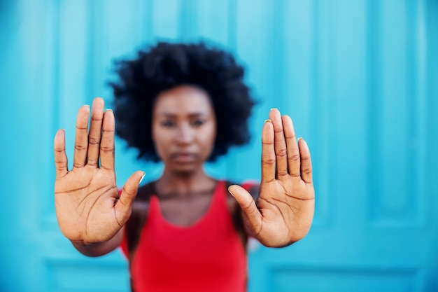 Primer plano de una mujer africana cogidos de la mano como una señal de stop.