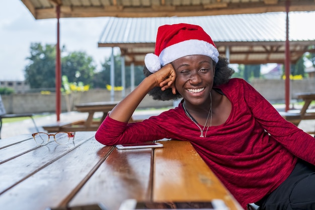 Primer plano de una mujer africana con un sombrero de Navidad con una gran sonrisa