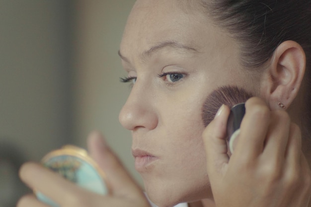 Primer plano de una mujer aplicando maquillaje