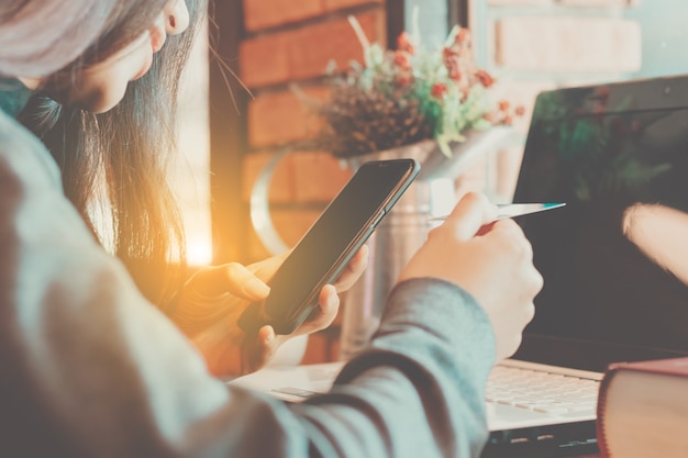 Primer plano de la mujer de Asia con teléfono inteligente en el tiempo libre con feliz.