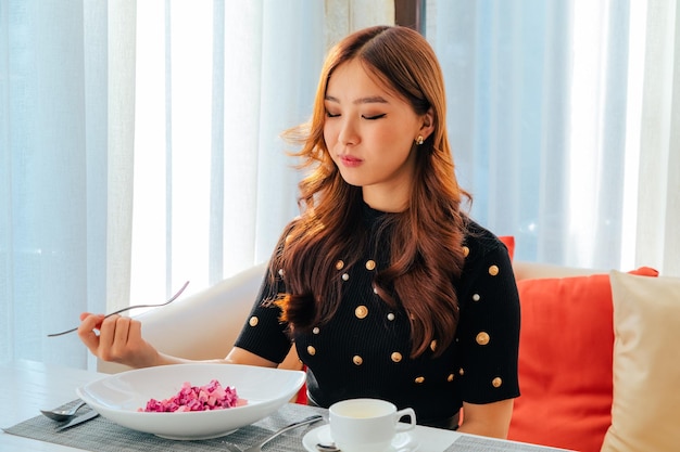 Primer plano de una mujer asiática comiendo ensalada de remolacha