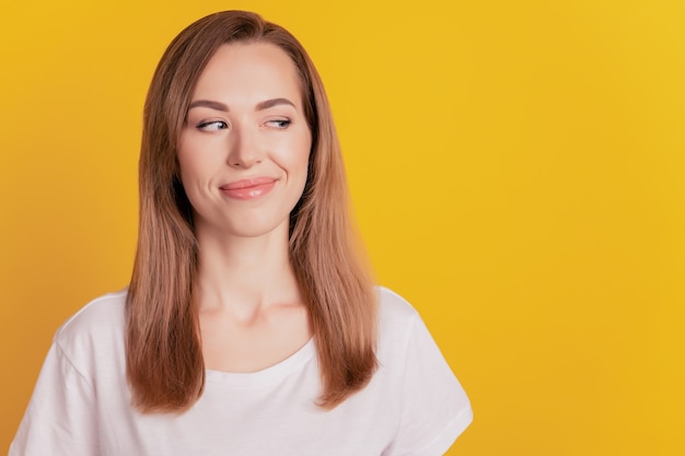 Foto primer plano de una mujer astuta cara sonrisa mirada lado espacio vacío