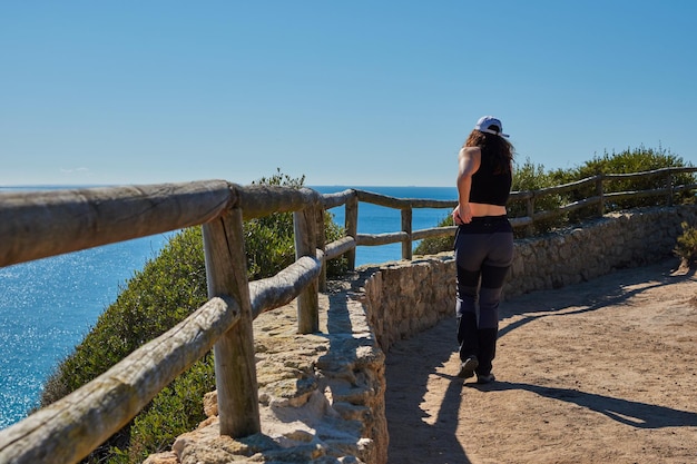 Un primer plano de una mujer desde atrás mirando el mar