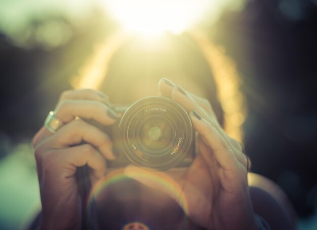 Foto primer plano de una mujer con una cámara en un día soleado