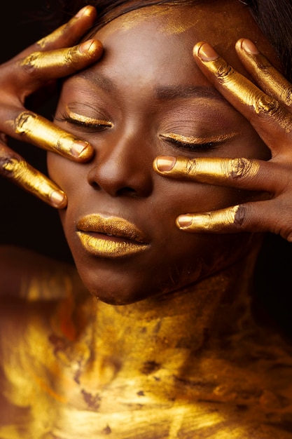 Primer plano de una mujer con la cara pintada de dorado