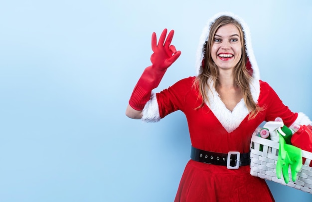 Primer plano de una mujer caucásica feliz con ropa de santa y guantes de limpieza con aerosoles de limpieza