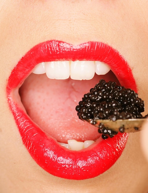 Primer plano de una mujer comiendo caviar