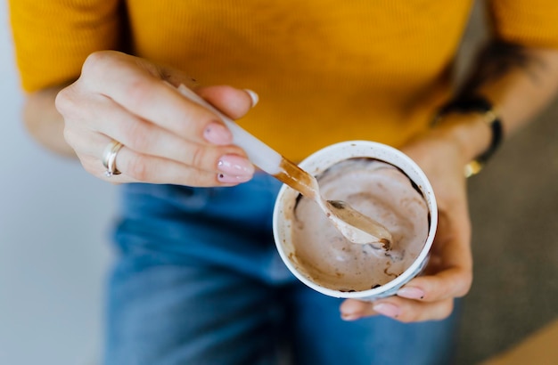 Primer plano de una mujer comiendo un helado de chocolate