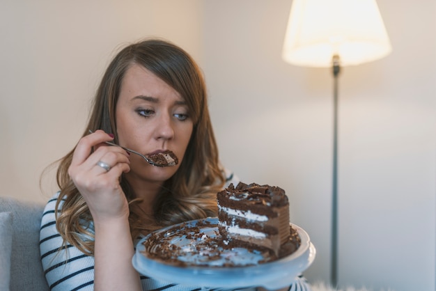 Primer plano de mujer comiendo pastel de chocolate.