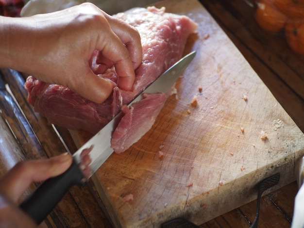 Primer plano de una mujer cortando carne