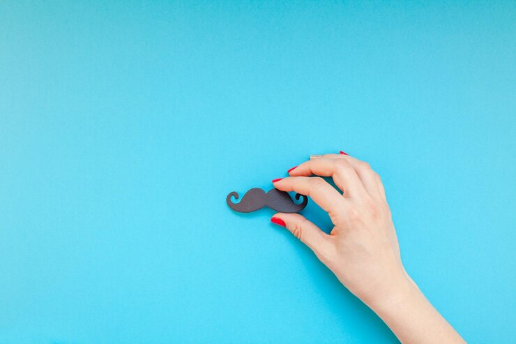 Foto primer plano de una mujer con un corte de bigote sobre un fondo azul