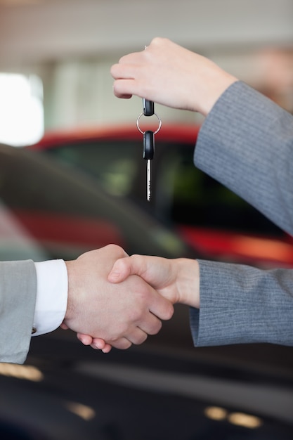 Primer plano de una mujer dando las llaves del coche a un hombre