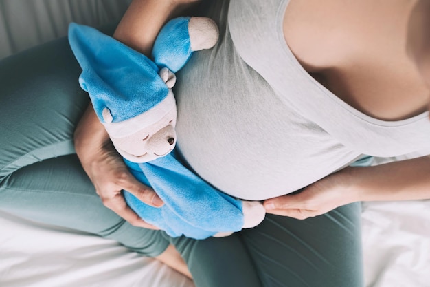 Primer plano de una mujer embarazada con un oso de peluche Concepto de crianza de la maternidad Prepararse y esperar al bebé Una madre embarazada feliz durante el embarazo