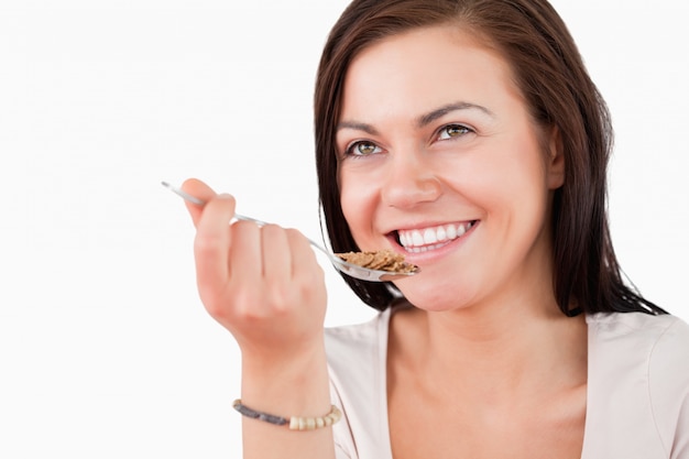 Primer plano de una mujer encantadora comiendo cereal