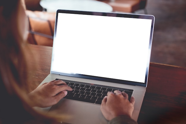 Foto primer plano mujer escribiendo vista trasera de la computadora portátil