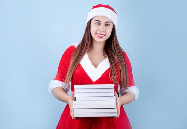 Primer plano de una mujer feliz caucásica con ropa de santa sosteniendo un montón de libros en blanco