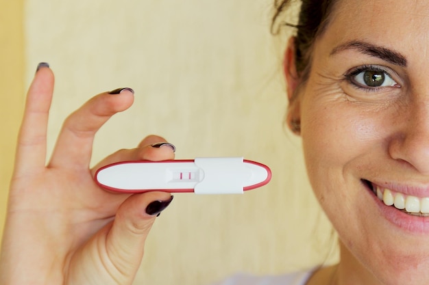 Primer plano de una mujer feliz mostrando una prueba de embarazo negativa