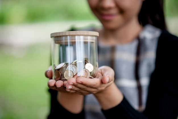 Foto primer plano de una mujer con un frasco de monedas