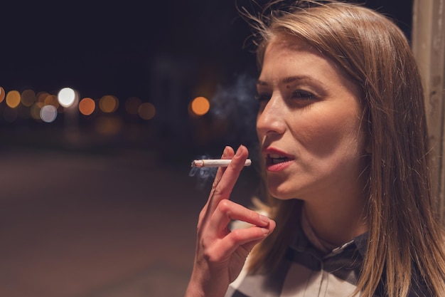 Foto primer plano de una mujer fumando un cigarrillo