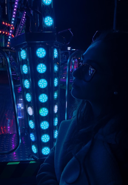 Primer plano de una mujer con gafas de sol por un equipo de iluminación iluminado