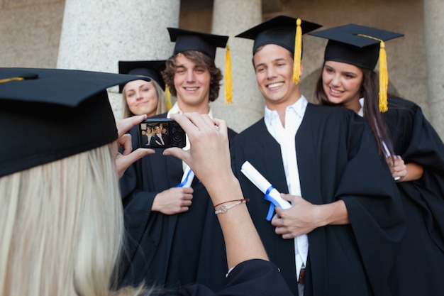 Foto primer plano de una mujer graduada tomando una foto de su amigo